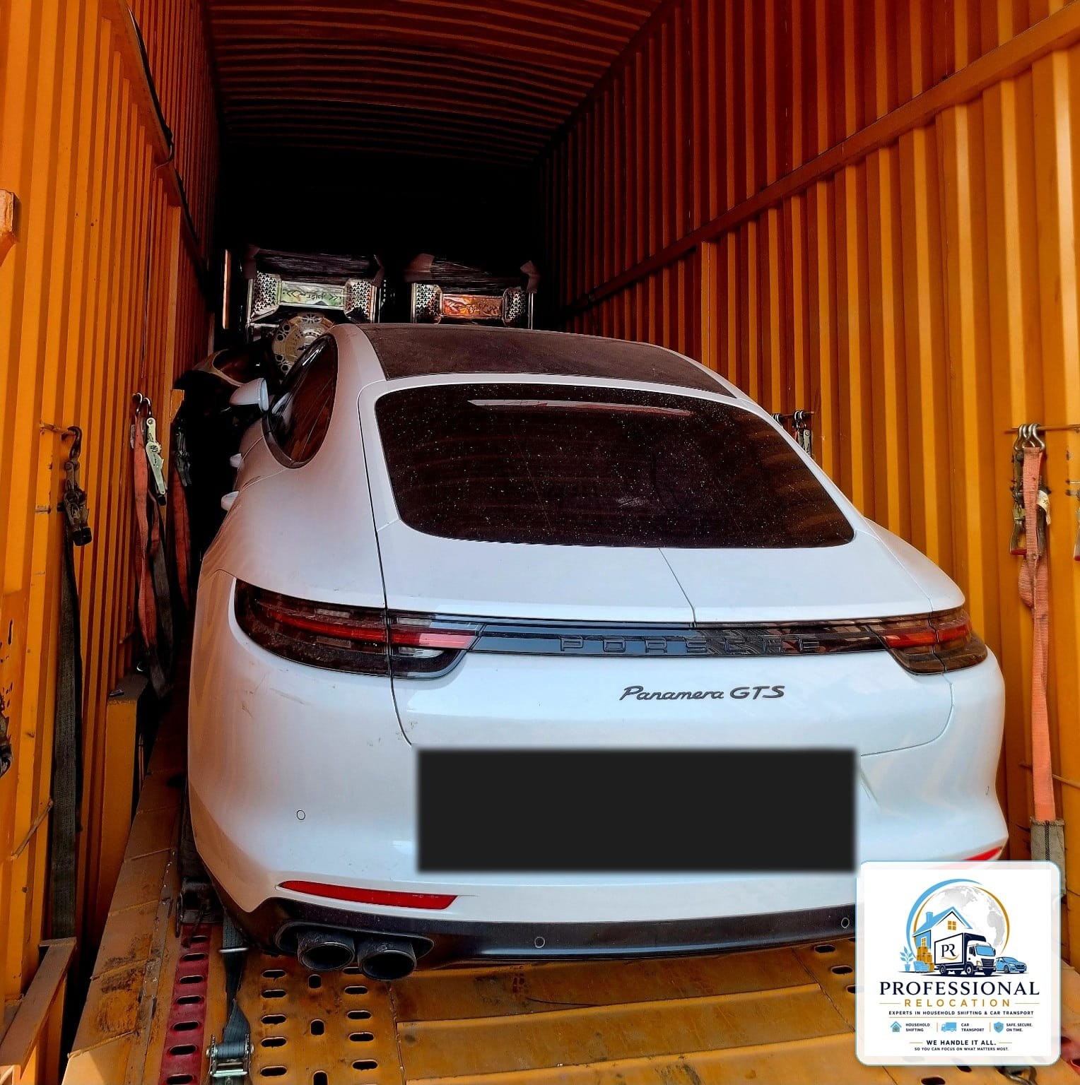 Porsche Panamera GTS strapped inside an enclosed carrier from Goa