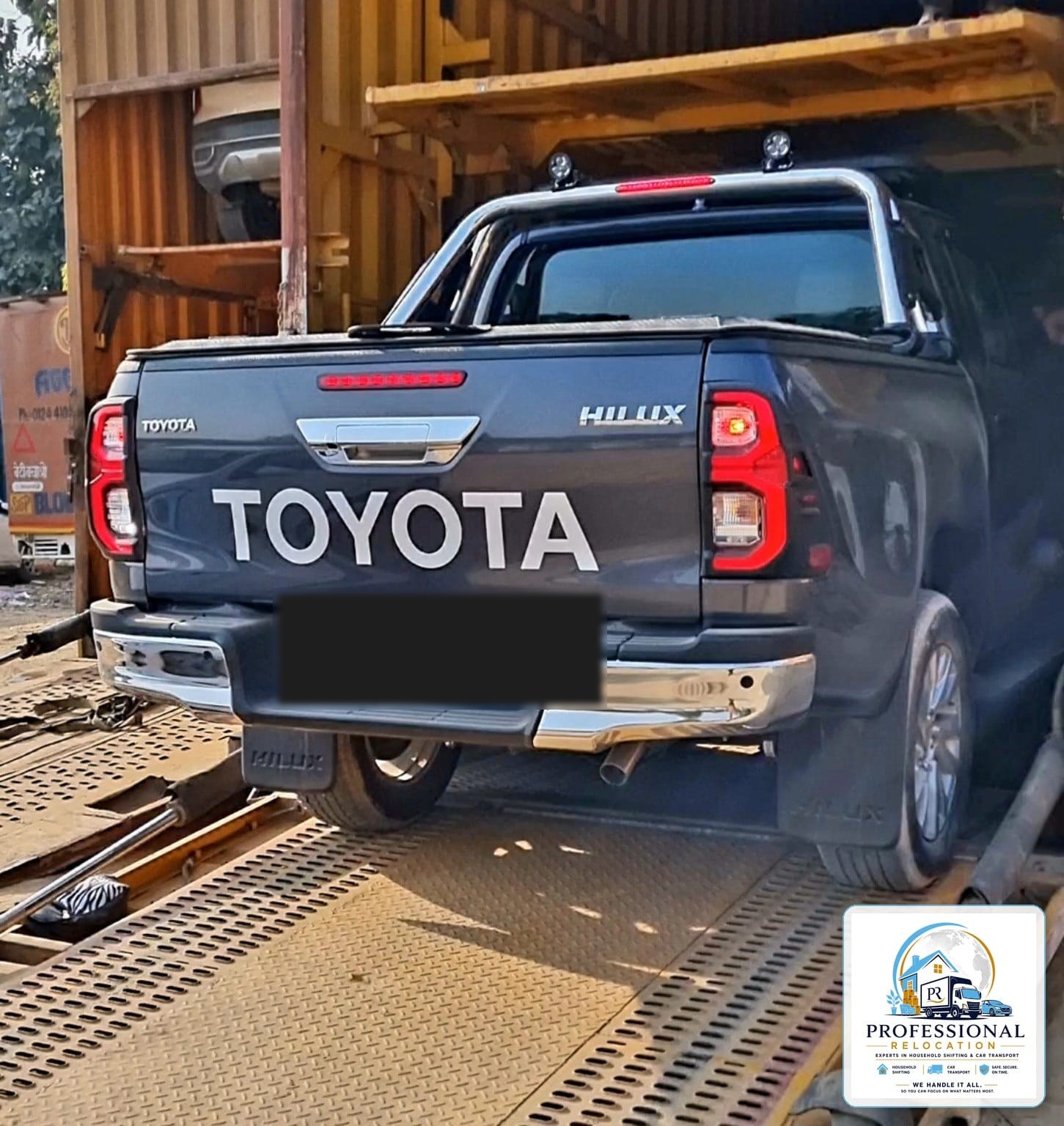 Toyota Hilux loaded onto an enclosed car carrier from Goa